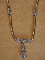 A yellow-gold dress ring with five baguette sapphires in a curved central row, channel-set with diamond accents either side.