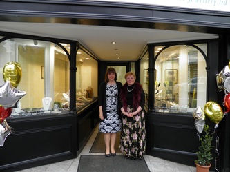 Two members of the Dewi Griffiths team standing in the open Bridgend shopfront doorway at 40 Caroline Street